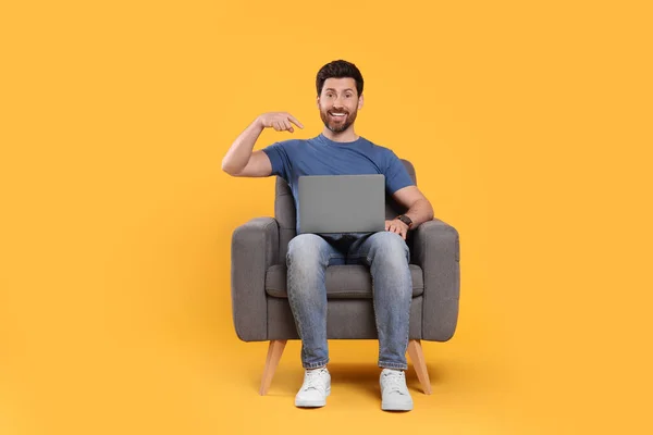 Homem Emocional Com Laptop Sentado Poltrona Contra Fundo Amarelo — Fotografia de Stock