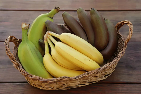 Cesta Vime Com Diferentes Tipos Bananas Mesa Madeira Close — Fotografia de Stock