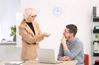 Patron ve çalışan ofiste iş meselelerini tartışıyor