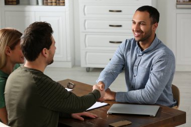 Ofiste müşteriyle tokalaşan noter.