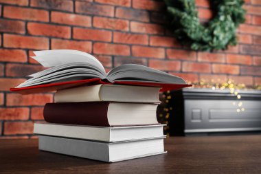 İçerideki ahşap masada bir yığın ciltli kitap.