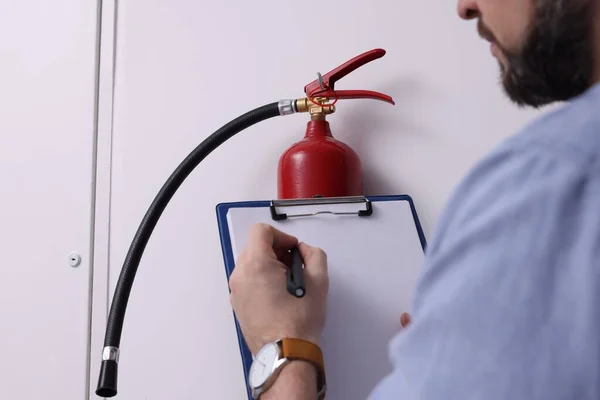 Hombre Con Portapapeles Comprobando Extintor Incendios Interiores Primer Plano —  Fotos de Stock