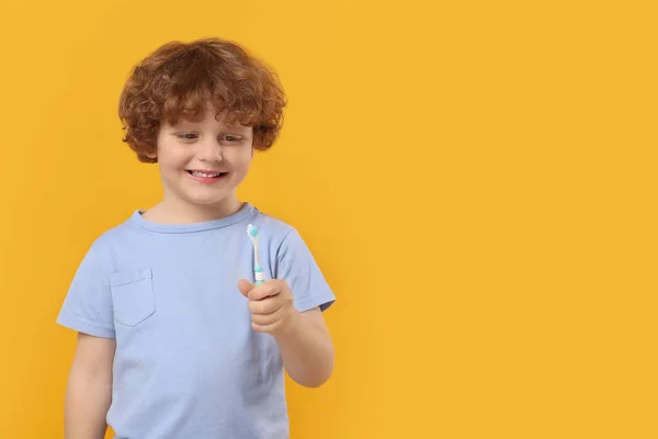 黄色の背景にプラスチック歯ブラシを保持かわいい男の子 テキストのためのスペース — ストック写真
