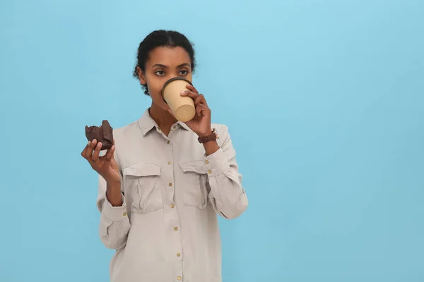 Estagiário Afro Americano Com Cupcake Bebendo Café Fundo Azul Claro — Fotografia de Stock
