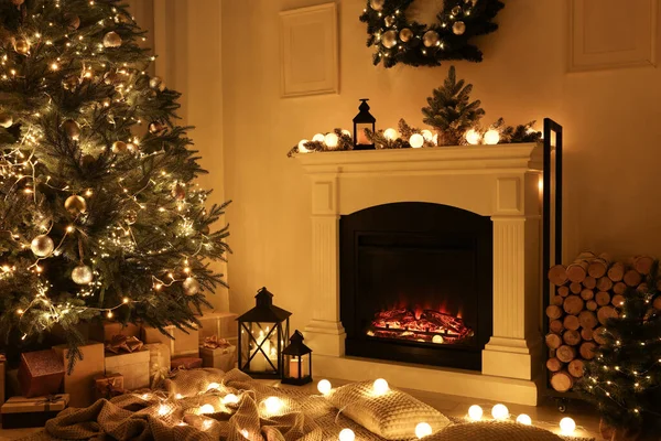 夜に燃える暖炉とクリスマスツリーと美しいリビングルームのインテリア — ストック写真