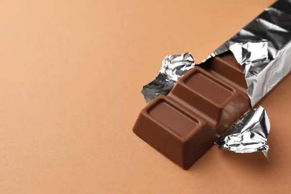 Läcker Choklad Bar Insvept Folie Ljusbrun Bakgrund Närbild Plats För — Stockfoto