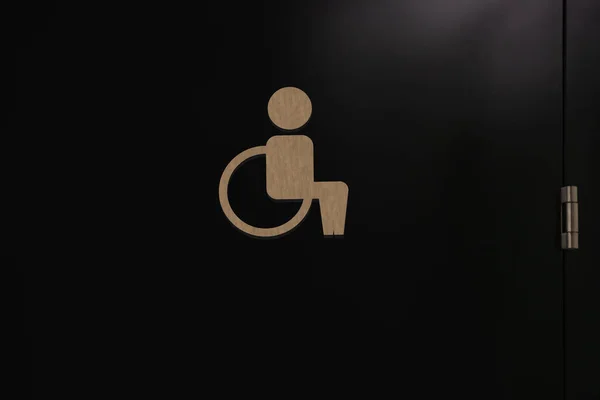 特別なニーズ黒のドアにアクセス可能な公衆トイレの看板 クローズアップ 車いすマーク — ストック写真