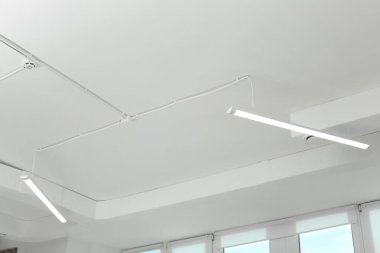 White ceiling with modern lighting in office