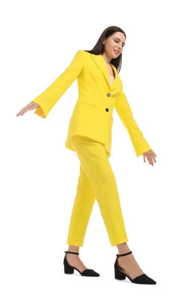 白い背景を歩く黄色のスーツの美しいビジネス女性 低角度ビュー — ストック写真