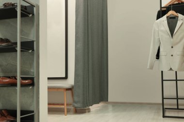 Moda mağazasında elbise askısı olan bir soyunma odası. Şık tasarım