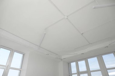 White ceiling with modern lighting in office