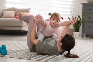 Anne kızıyla evde egzersiz yapıyor.