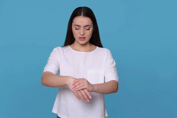 Mulher Jovem Que Sofre Dor Nas Mãos Fundo Azul Claro — Fotografia de Stock