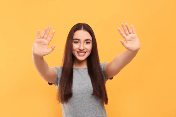 Lycklig Kvinna Ger Hög Fem Med Båda Händerna Orange Bakgrund — Stockfoto