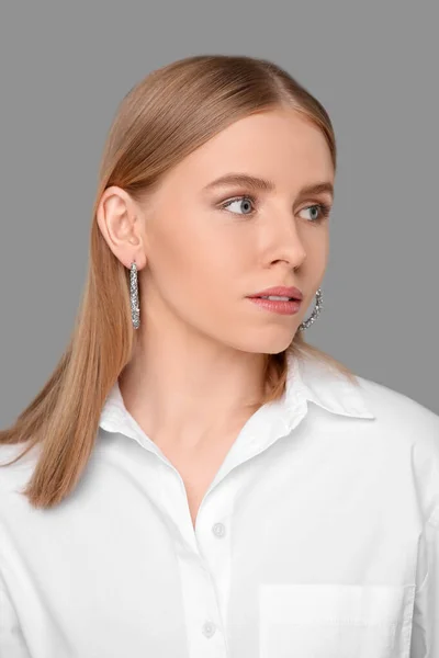 Schöne Junge Frau Mit Eleganten Ohrringen Auf Grauem Hintergrund — Stockfoto