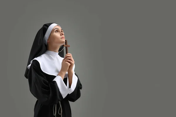 灰色の背景で神への十字架の祈りを持つ修道女 テキストのスペース — ストック写真