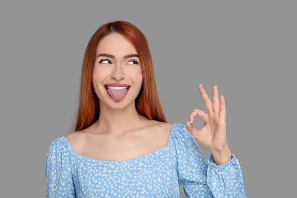 Ευτυχισμένη Γυναίκα Δείχνει Γλώσσα Της Και Χειρονομία Γκρι Φόντο — Φωτογραφία Αρχείου