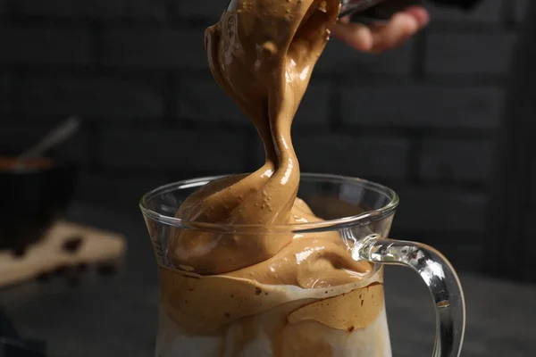 ダーゴナコーヒーのためのクリームを暗い背景にガラス製のマグカップに入れ クローズアップ — ストック写真