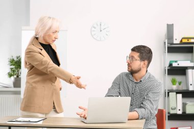 Duygusal patron ve kafası karışık çalışan ofiste iş meselelerini tartışıyor.