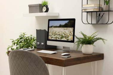 Cozy workspace with computer on wooden desk at home