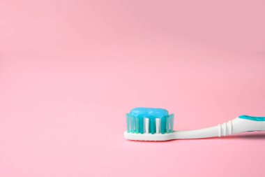 Pembe arkaplanda fırça ve diş macunu, metin için boşluk