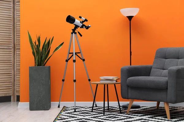 Moda odasında modern teleskopu olan tripod.