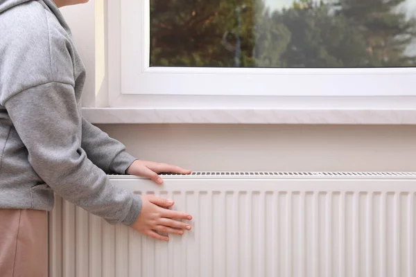Girl Warming Hands Heating Radiator Indoors Closeup — Zdjęcie stockowe