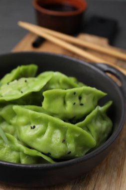 Ahşap masada lezzetli yeşil hamur tatlısı (gyozas), yakın plan.