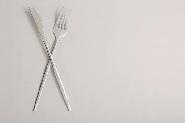 浅灰背景上的叉子和刀 平平铺 案文的篇幅 — 图库照片