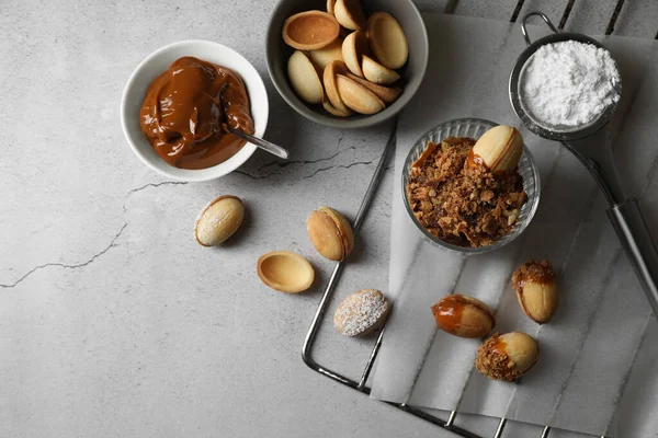 Lezzetli ceviz şekilli kurabiyeler. Yoğunlaştırılmış süt, gri masada, düz yerde.
