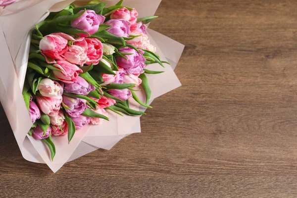 stock image Bouquet of beautiful tulips on wooden table, closeup. Space for text