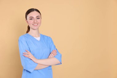 Açık kahverengi arka planda tıp üniformalı hemşire portresi, metin için boşluk