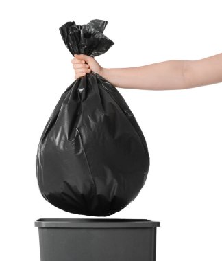 Woman holding trash bag full of garbage over bucket on white background, closeup