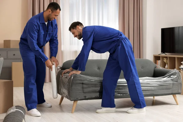 Male Movers Stretch Film Wrapping Sofa New House — Foto de Stock