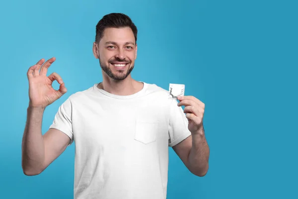 Homem Feliz Com Preservativo Mostrando Gesto Fundo Azul Claro Espaço — Fotografia de Stock