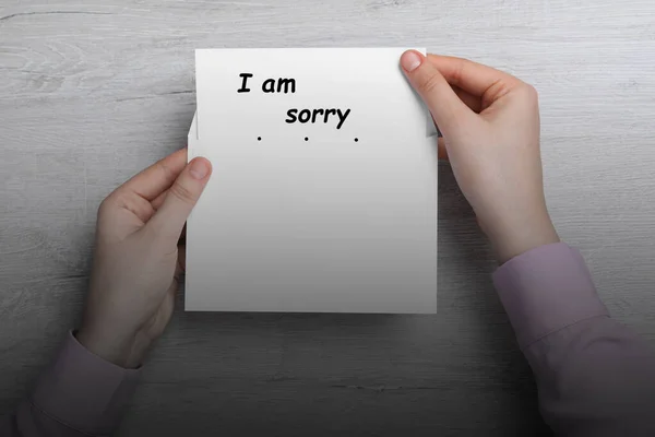 Przeprosiny Kobieta Biorąca Kartkę Frazą Przepraszam Koperty Przy Drewnianym Stole — Zdjęcie stockowe
