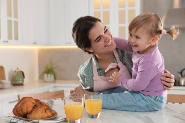 Anne ve küçük kızı mutfakta kahvaltı ediyorlar.