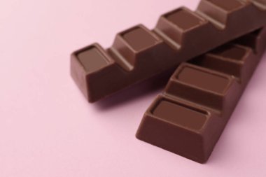 Pembe arka planda lezzetli çikolatalar, yakın plan.
