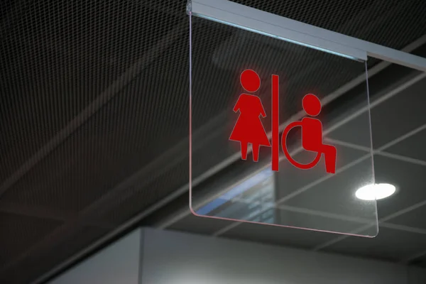 室内悬挂透明玻璃上的红色公厕标志 — 图库照片