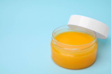 Açık mavi arka planda bir kavanoz petrolatum açın. Metin için boşluk