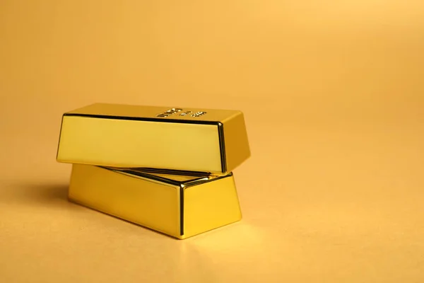Glänzende Goldbarren Auf Blassorangefarbenem Hintergrund Nahaufnahme Raum Für Text — Stockfoto
