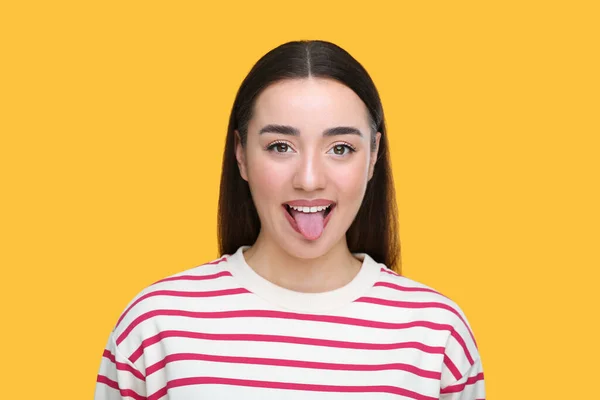 幸せな女性ショー彼女の舌上のオレンジ背景 — ストック写真