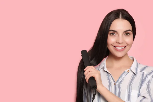 Schöne Glückliche Frau Mit Haarbügeleisen Auf Rosa Hintergrund Raum Für — Stockfoto