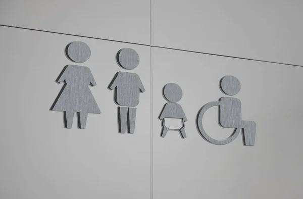 光の壁に灰色の公衆トイレの標識 — ストック写真