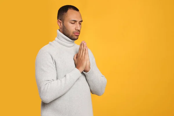 Afroamerykanin Zaciśniętymi Rękami Modlący Się Boga Pomarańczowym Tle Miejsce Tekst — Zdjęcie stockowe