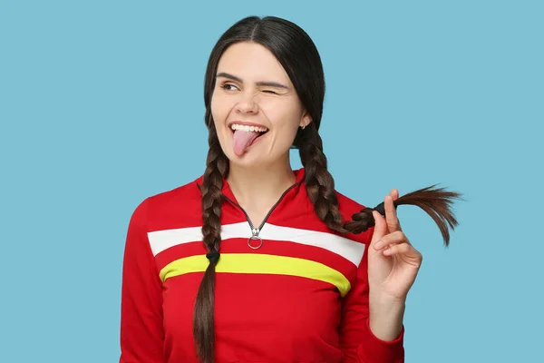 Dilini Açık Mavi Arka Planda Gösteren Mutlu Genç Bir Kadın — Stok fotoğraf