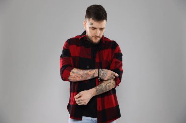 Açık gri arka planda yakışıklı hippi.