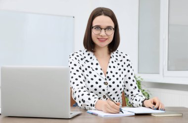 Modern ofisteki masada çalışan mutlu genç stajyer.