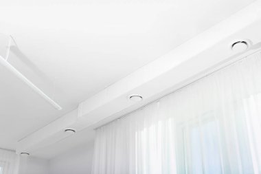White ceiling with modern lighting in office