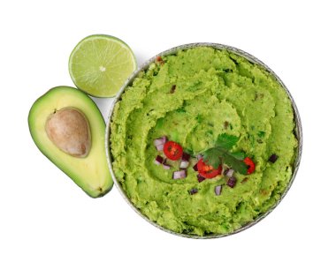 Bir kase lezzetli guacamole, taze avokado ve beyaza izole edilmiş limon.